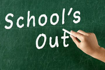 Naklejka premium Female hand writing on blackboard with chalk, close up