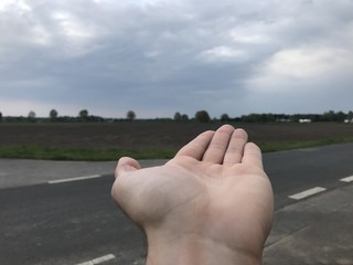 Handfläche vor Regenwolken