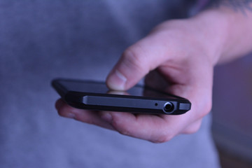 Man holding telephone and typing