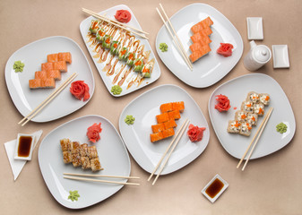 Delicious sushi on different plates on the table in the restaurant top view