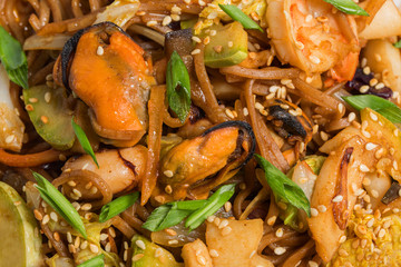buckwheat noodles with seafood on white plate in restaurant