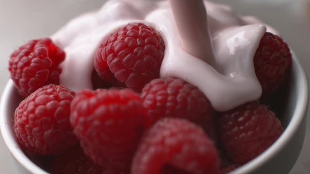 Yogurt pouring onto fresh raspberries in super slow motion, shot on Phantom Flex 
