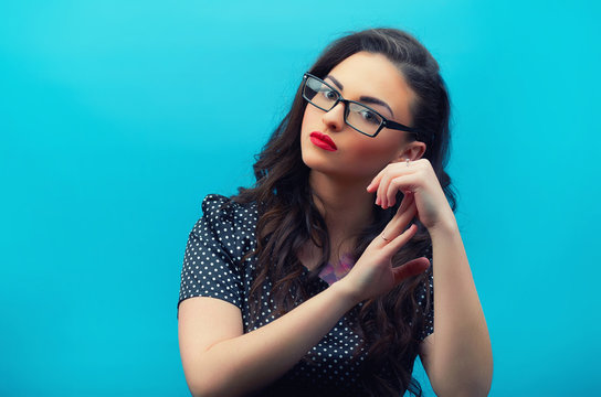 Portrait of the beautiful young woman in glasses on the black  polka dot  dres