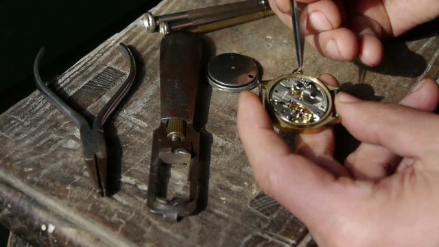 Mounting screw of watch on wood desk,A lot of tools.