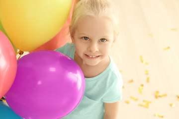 Fototapeta na wymiar Cute little girl with colorful balloons at birthday party