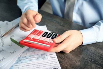 Man working with calculator and documents. Tax concept
