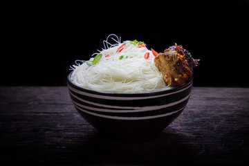 Instant vermicelli in the bowl on wooden background