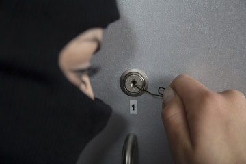 Fototapeta premium Burglar in action, trying to open the lock