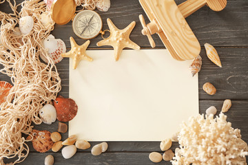 Travel concept. Composition with paper and sea shells on wooden background