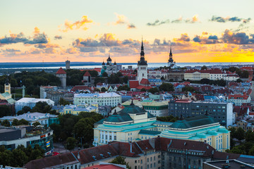 TALLINN, ESTONIA - JULY, 30, 2016: Orange sunset over old town. Cathedrals towers and medieval buildings aerial view. Panoramic view.