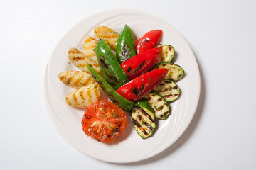 Grilled vegetables - zucchini potato and tomato. White background