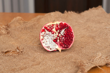 A half of pomegranate on the sackcloth texture background