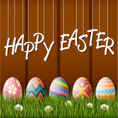 Happy easter with eggs and grass on wood background