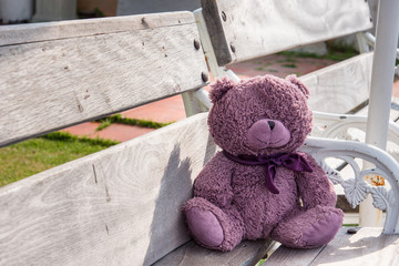 Teddy bears sitting on a wooden chair.
