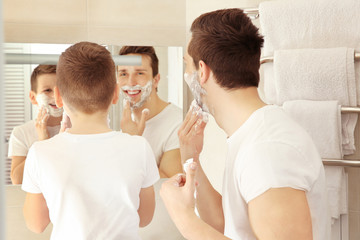 Obraz na płótnie Canvas Father and son shaving in bathroom