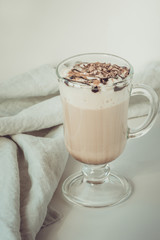 Coffee latte with thick foam and grated chocolate in glass. Vintage toned.