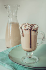 Coffee latte with thick foam and grated chocolate in glass. Vintage toned.