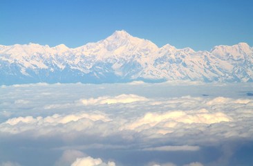 Obraz na płótnie Canvas Aerial view from an airplane over the Himalayas and Everest mountain on blue sky