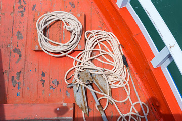 Rope and Small anchor on board ship deck.