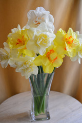 a bouquet of white and yellow daffodils in a glass vase