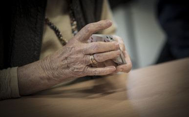 Obraz na płótnie Canvas Senioren Hände beim Kartenspiel Häusliche Altenpflege