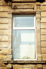 Vintage building with modern white plastic window