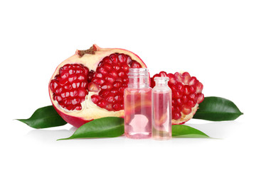 Perfume bottles and pomegranate on white background