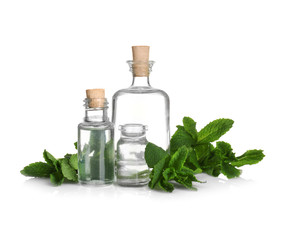 Perfume bottles and fresh mint on white background