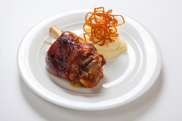 Bavarian roasted knuckle of pork and mashed potatoes on bright background