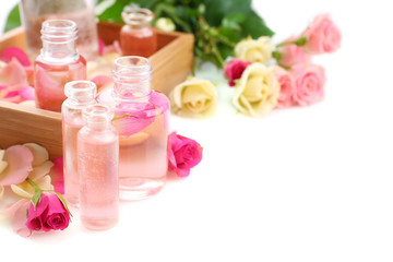 Beautiful composition with perfume bottles and roses on white background