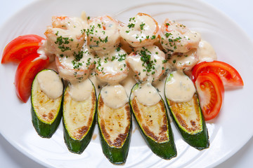 shrimps and grilled zucchini on a white plate