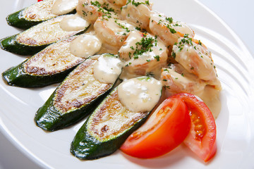 shrimps and grilled zucchini on a white plate