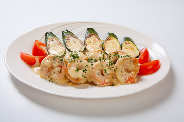 shrimps and grilled zucchini on a white plate