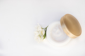 Face cream with spring flowers on white background.