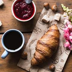 Coffee croissant on old wooden table background