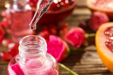 Perfume bottle and pipette with oil drop, closeup