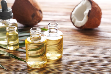 Perfume bottles and fresh coconut on wooden table