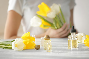 Perfume bottles on table and blurred woman on background