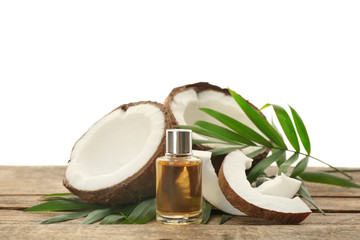 Bottle with fresh coconut oil and nut on wooden table