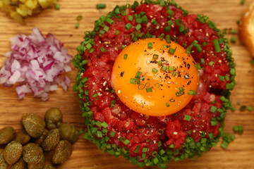 Raw meat tartare steak with egg yolk close up