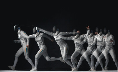 Full-length portrait of woman wearing white fencing costume on black