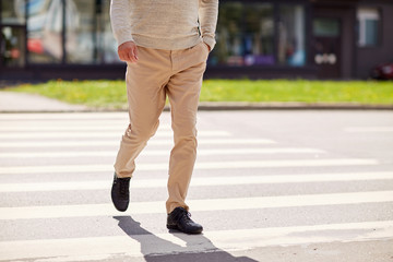 senior man walking along city crosswalk