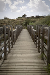 Old wooden bridge rises a river on a quiet and lonely cloudy day
