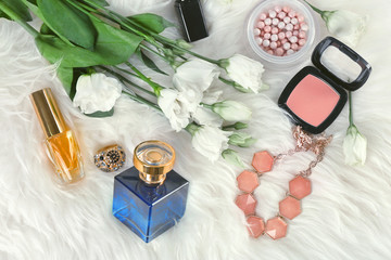 Beautiful composition with perfume bottle and flowers on furry background