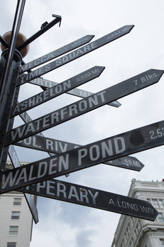 Isolated  Dramatic Upward View, Left-Hand Composition, , Famous Black Signpost Directions to World Landmarks Pioneer Courthouse Square,  Older Building Tops in Background, Sky Backdrop Daytime - Portl