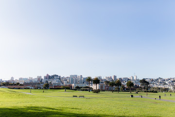 Fototapeta na wymiar San Francisco park with skyline at sunrise