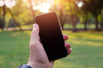 Man uses his Mobile Phone outdoor, close up, capture the moment by a smart phone blank screen in my hands, blank screen.