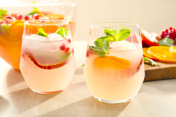 Two glasses of fresh cocktail with pomegranate and orange on table