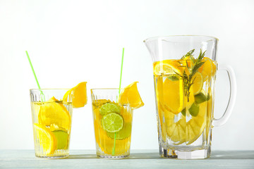 Glasses and jug with fresh lemonade on table