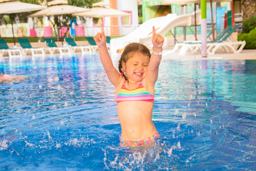 Naklejka premium A little child is dancing in the pool.